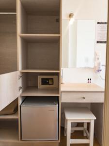 a small kitchen with a desk and a microwave at Golden Sun in Ios Chora