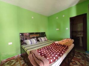 a bedroom with a bed with green walls at Pandavas Homestay in Rudraprayāg