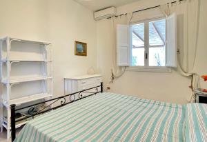 a bedroom with a bed and a window at Casa Kairos - Torre dell'orso in Torre dell'Orso
