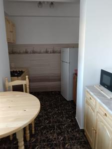 a kitchen with a table and a refrigerator at Seven Apartament in Mangalia