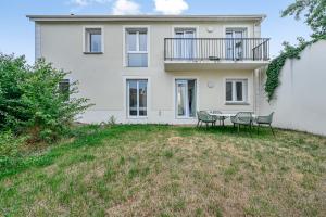 a house with a table and chairs in front of it at Casa di Luce - Garden - 9 people - Close to La Défense in Bezons