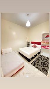 达赫拉Dakhla sky blue的一间带两张床的卧室和地毯