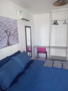 a bedroom with a blue bed and a pink chair at Loft Apartamento Terreo Deck em São José in São José