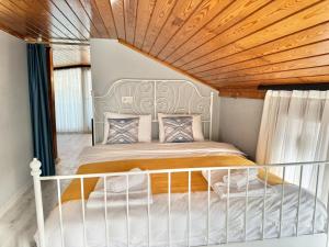 - une chambre avec un lit blanc et un plafond en bois dans l'établissement White Inn Taksim, à Istanbul