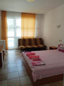 a bedroom with two beds and a large window at Sani Family Hotel in Byala