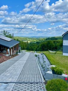a cobblestone road in front of a building at Domek Na Wzgórzu Roztocze in Majdan Abramowski