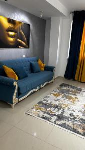 a blue couch in a living room with a painting at M Luxury Apartment in Timişoara