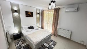 a bedroom with a bed and a large window at M Luxury Apartment in Timişoara