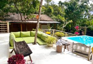 a patio with a couch and a swimming pool at Suítes na Vila Mansinha - perto do quadrado in Trancoso