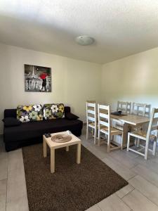 a living room with a black couch and a table at Guest house Ema in Grabovac
