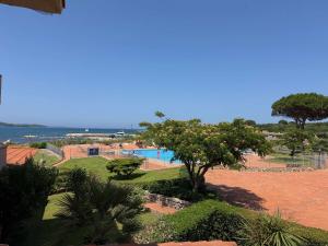 a view of a swimming pool with trees and the ocean at Sardegna Beach Cala Reale in Santa Marinella
