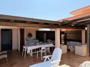 a patio with a table and chairs on a patio at Sardegna Beach Cala Reale in Santa Marinella