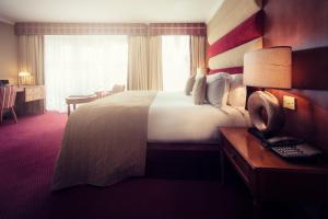 Postel nebo postele na pokoji v ubytování Carlton George Hotel