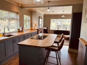 a kitchen with a large island with a wooden counter top at Oaken Fields, Waddington, Clitheroe in Waddington +26 photos