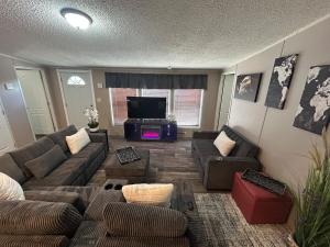 a living room with couches and a flat screen tv at Cozy river front lookout in Bullhead City