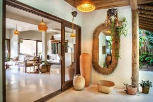 a living room with a mirror and a couch at Suítes na Vila Mansinha - perto do quadrado in Trancoso