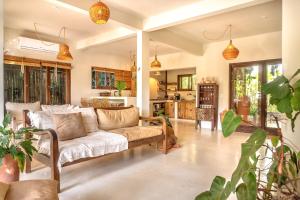 a living room with a couch and some plants at Suítes na Vila Mansinha - perto do quadrado in Trancoso