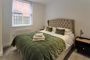 een slaapkamer met een groot bed en een groene deken bij Stunning Caterham 4 bedroom home in Kenley