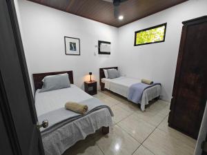 a bedroom with two beds and a window at AJ Suites - Modern Beach Apartments with Pool and Full Kitchen in Uvita