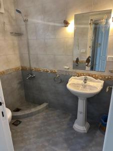 a bathroom with a sink and a shower with a mirror at Superior Chalet Marina 4 in El Alamein