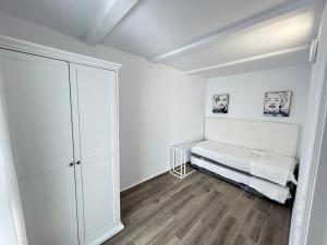 a white room with a bed and a closet at Apartamento Empul Barrosa Beach in Novo Sancti Petri