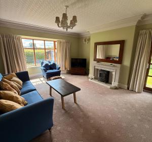 a living room with a blue couch and a fireplace at Oaken Fields, Waddington, Clitheroe in Waddington