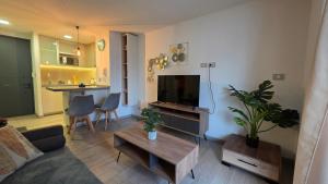 a living room with a couch and a tv and a table at Oceana Suites Eco Costas in Concón