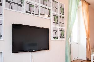 a flat screen tv hanging on a white wall with pictures at Apartlux on Karetnyy Ryad in Moscow