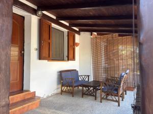 a patio with a table and chairs on a porch at La Borgata - Guest House in Campanedda