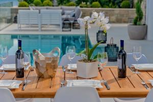 drewniany stół z kieliszkami do wina i rośliną w obiekcie Spectacular Korcula Villa 4 Bedrooms Villa Korcula Grandeur Private Infinity Pool Stunning Sea Views Zrnovo w Korčuli