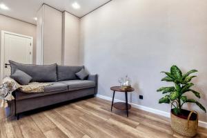 a living room with a couch and a potted plant at Уютная евро-двушка возле ботанического сада in Astana