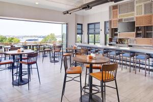 a restaurant with tables and chairs and a large window at Hilton Garden Inn Providence in Providence