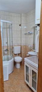 a bathroom with a toilet and a tub and a sink at Apartments Aurora in Bar +33 photos