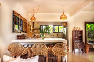a kitchen with rattan chairs and a wooden table at Suítes na Vila Mansinha - perto do quadrado in Trancoso +24 photos