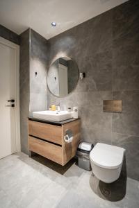 a bathroom with a sink and a toilet and a mirror at Casa Lux Apartment in Belgrade