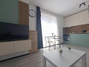 a living room with a kitchen and a table with chairs at Mareya Sky Residence Including Underground Parking Place in Sofia