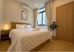 a bedroom with a bed with a stuffed animal on it at Tranquil City Center Wabi Sabi 3BR Townhouse in D1 in Ho Chi Minh City