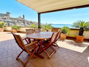 a table and chairs on a patio with a view of the ocean at Terrazza da Sogno con Vista su Castello e Lago in Bracciano