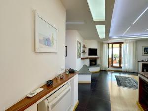 a living room with white walls and black tile floors at Terrazza da Sogno con Vista su Castello e Lago in Bracciano