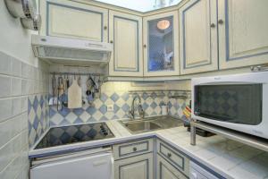 une cuisine avec un évier et un micro-ondes dans l'établissement House with garden & jacuzzi near city center, à Saint-Tropez