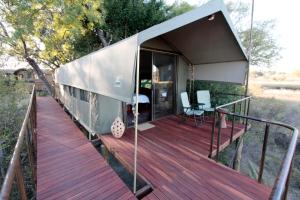 una casa con terraza y escritorio. en Nkasa Lupala Tented Lodge, en Sangwali