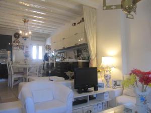 a living room with white furniture and a television at Diles Complex Apartment in Ornos