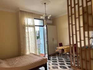 a room with a bed and a table and a window at Green House in K'obulet'i