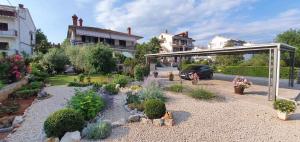 einen Garten mit Blumen und Pflanzen im Hof in der Unterkunft Apartment Malinska, Primorje-Gorski Kotar 1 in Malinska