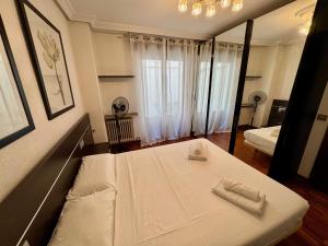 ein Schlafzimmer mit einem Bett mit zwei Handtüchern darauf in der Unterkunft Apartamento Reyes de España / Free Parking & Wi Fi in Salamanca