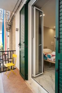 a room with a green door and a yellow chair at Experience Napoli Center in Naples