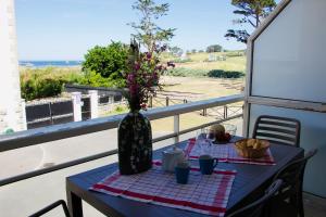 プルガヌーにあるAppartement vue mer, GR 34 et plage au pied !のバルコニーの上に花瓶付きテーブル