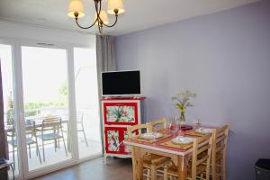 プルガヌーにあるAppartement vue mer, GR 34 et plage au pied !のダイニングルーム(テーブル、テレビ付)