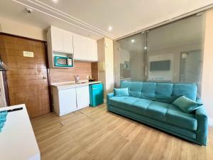 a living room with a blue couch in a kitchen at Elegance Comfort Natal Beira Mar in Natal
