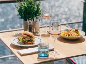 a table with two plates of food and glasses of wine at Fairmont Hotel Vier Jahreszeiten in Hamburg